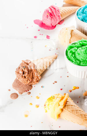 La fonte des glaces faites maison différente de la crème dans des bols et waffle ice cream cones, blanc vanille, orange, rose berry, vert, bleu, chocolat blanc en backg Banque D'Images