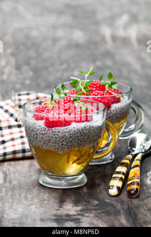 Semences Chia pudding avec la marmelade d'orange et framboises fraîches sur la table en bois Banque D'Images