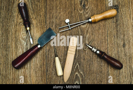 Outils d'artisanat du cuir sur fond de bois Banque D'Images