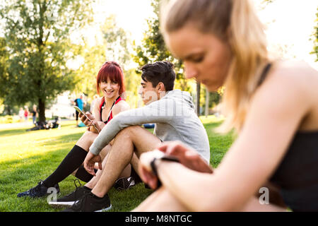 Groupe de jeunes coureurs se reposant dans un parc. Banque D'Images