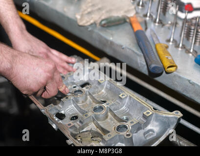 La réparation des mains d'hommes chef d'un bloc-cylindres, gros plan intérieur Banque D'Images