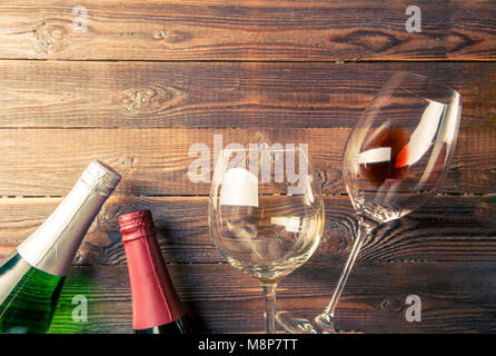 Photo le haut de deux bouteilles de vin et des verres à vin sur brown, fond de bois. Banque D'Images