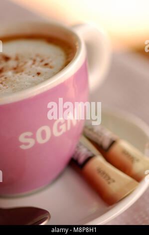 Tasse à café avec cappucino Sogni soucoupe et cuillère à café de sucre dans la tasse rose Banque D'Images