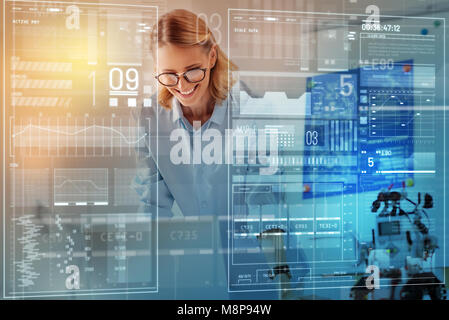 Ingénieur en souriant regardant les documents tout en travaillant dans son bureau Banque D'Images