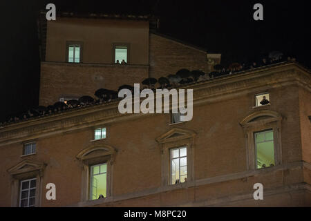 La cité du Vatican. Les gens par la fenêtre comme d'autres donnent sur d'un toit au-dessus tandis que le pape nouvellement élu François I s'affiche sur le balcon central de Banque D'Images