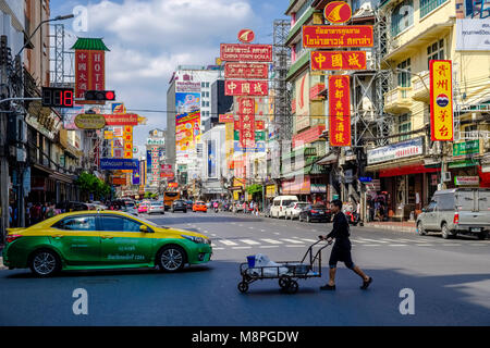 Scène de rue avec un taxi, un homme poussant un chariot et de nombreuses publicités dans Chinatown Banque D'Images