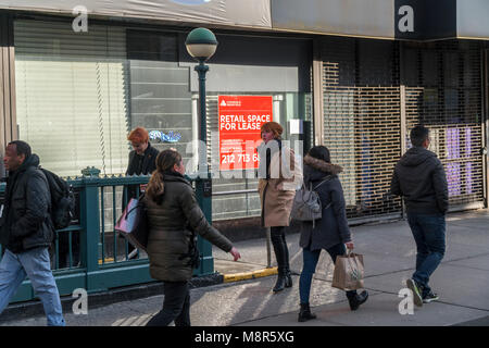 Les banlieusards entrez le métro en face de l'espace de vente au détail, récemment libéré par un salon de manucure, dans le quartier de Chelsea, New York le Mardi, Mars 13, 2018. Les propriétaires sont plus disposés à s'occupe des locataires résultant des loyers plus réaliste et de plus en plus de magasins restent vacants, victime de magasinage en ligne. ( Â© Richard B. Levine) Banque D'Images