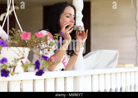 Jeune fille sur le porche de la maison manger pastèque doux Banque D'Images