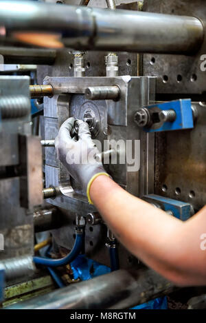 Homme d'ouvrier employé travaillant sur la réparation de la machine pour le travail, une main dans la main vu dans close-up Banque D'Images
