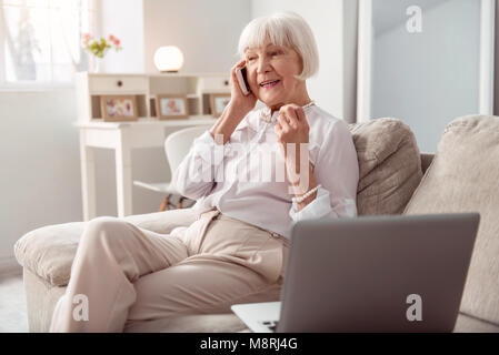 Vieille Femme agréable au téléphone heureusement Banque D'Images