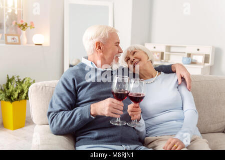 Joli couple de personnes âgées faire des toasts et clinking glasses Banque D'Images