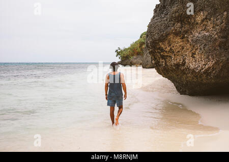 Vue arrière de l'homme marchant sur le rivage contre sky at beach Banque D'Images
