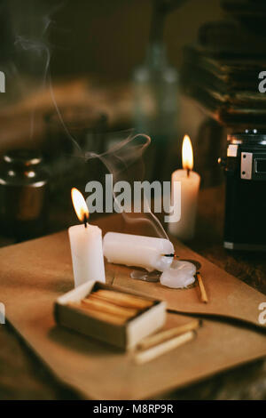 High angle view of burning candles avec matchbox et envelopper sur table Banque D'Images