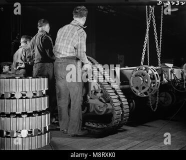 Groupe de travailleurs sur la courroie de fixation du châssis du tracteur de semi-chenillé de l'Armée de Scout Car à l'usine convertie à la production de guerre, White Motor Company, Cleveland, Ohio, USA, Alfred T. Palmer pour l'Office of War Information, décembre 1941 Banque D'Images