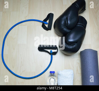 Corde en forme G , kick boxing gloves , bouteille d'eau , serviette et matelas rollable sur fond de bois Banque D'Images