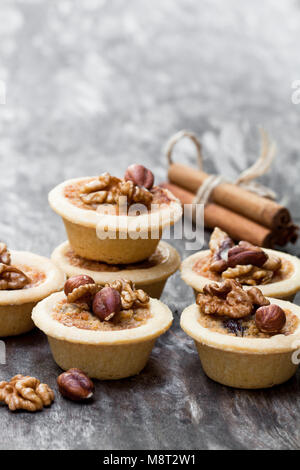 Mini tartelettes aux noix et au gingembre sur fond de bois Banque D'Images