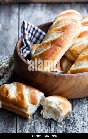 Mini miche de pain dans un bol en bois et les épis de blé sur table en bois Banque D'Images