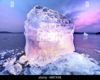 Pièces de fonte de blocs de glace. Rétroéclairage de couleur forte brillance des fissures profondes, low angle view. Loin de l'horizon. Banque D'Images