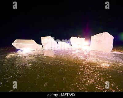 Pièces de fonte de blocs de glace. Rétroéclairage de couleur forte brillance des fissures profondes, low angle view. Loin de l'horizon. Banque D'Images