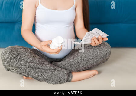 Pregnant woman holding bottle of pills Banque D'Images