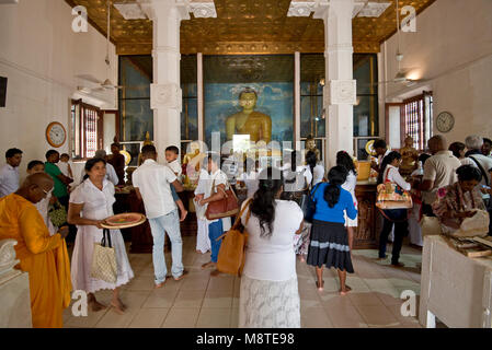 La population locale et aux pèlerins de prier et de donner des cadeaux de fleurs au Jaya Sri Maha Bodhi temple à Anuradhapura, Sri Lanka. Banque D'Images