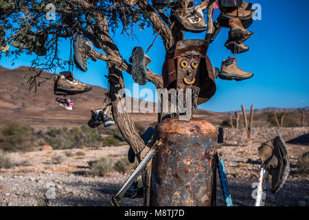 Une sculpture de métal en face d'un arbre décoré avec des chaussures à la rivière Tsauchab camp Banque D'Images