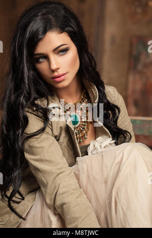 Fashion Studio Photo de la superbe jeune femme avec des cheveux bouclés dans l'élégant quartier de tenue et les accessoires Banque D'Images