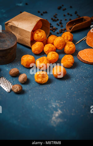 Croquettes de pomme de terre douce sur fond bleu, l'espace pour votre texte Banque D'Images