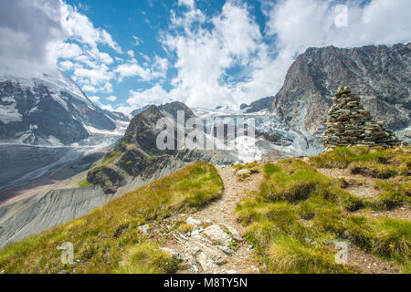 Pile de roche, marquant la fin de la piste juste en dessous de la Matterhorn glacier, dans les Alpes suisses. Imposant de glace, neige et moraine, Grassy hill. Banque D'Images