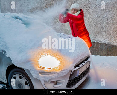 Brossage de la femme de sa voiture de la neige Banque D'Images