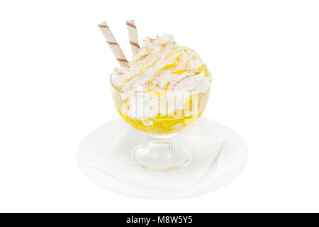 Dessert crème glacée à la crème fouettée isolé sur un fond blanc dans un verre transparent avec ananas, abricot, orange, confiture de citrouille, wafer tu Banque D'Images