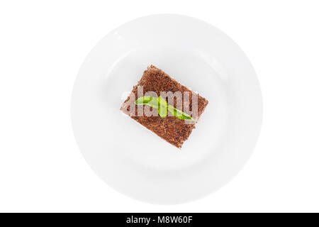 Morceau rectangulaire de Tiramisu avec une feuille de menthe sur une plaque blanche. isolé sur fond blanc. Dessert pour un menu dans un café, restaurant, café sh Banque D'Images