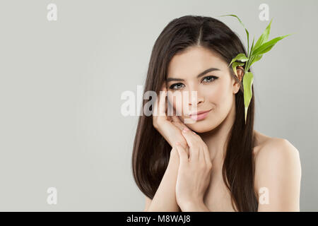 Belle Femme en bonne santé avec des feuilles de bambou vert. La peau douce et cheveux parfait Banque D'Images