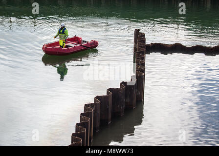 20 mars 2018, l'Allemagne, Frankfurt am Main : un travailleur d'une firme spécialisée pour travailler sous l'eau dans un bateau sur la grande fosse de la construction, qui a rempli avec de l'eau souterraine, pour le nouveau Terminal 3. Photo : Frank Rumpenhorst/dpa Banque D'Images