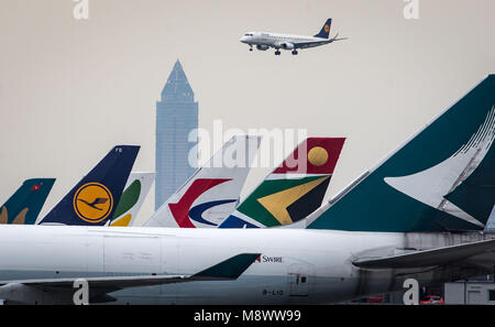 20 mars 2018, l'Allemagne, Frankfurt am Main : un avion de Lufthansa en venir à terre sur les avions en stationnement à l'aéroport de Francfort. La Messeturm (Salon Tower) peut être vu dans l'arrière-plan. Photo : Frank Rumpenhorst/dpa Banque D'Images