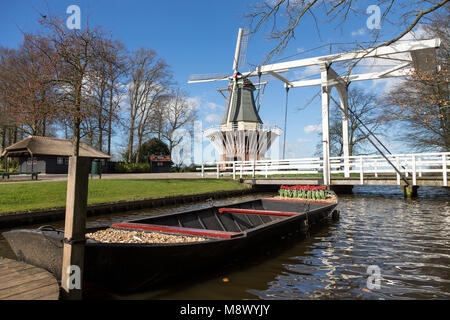 Lisse, Pays-Bas. Mar 20, 2018. Ouverture officielle de la saison 2018 Les jardins de Keukenhof. Scène typiquement hollandais avec moulin, pont-levis et un bateau dans le Keukenhof jardin ensoleillé. Photo : Marcel van den Bos/Alamy Live News Banque D'Images