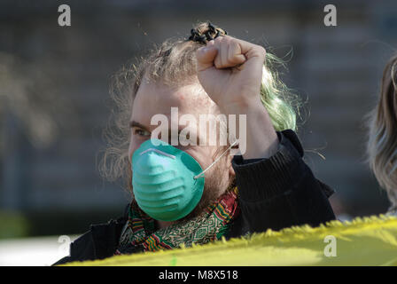 Glasgow, Royaume-Uni. Mar 20, 2018. Un manifestant des gestes avec sa main au cours d'une manifestation à Glasgow's George Square en face de la ville de Glasgow comme il se tient derrière un panneau ''Glasgow's Kids ont besoin d'air pur !'' à une manifestation contre la GCC Anti-Pollution Zone environnementale va échouer les plans de lutte contre la pollution de l'air toxique assez rapidement. Crédit : Stewart Kirby/SOPA Images/ZUMA/Alamy Fil Live News Banque D'Images