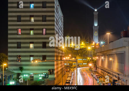 Afficher le long de la Via Milano à Gênes avec feux de circulation se précipiter dans la distance où le célèbre symbole de la ville, le phare, est allumé Banque D'Images