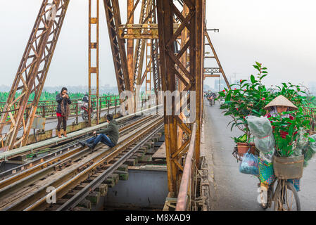 Le pont Long Bien à Hanoi, comme l'ensemble du cycle les navetteurs pont Long Bien deux jeunes une scène photo-shoot improvisé sur sa ligne de chemin de fer, Hanoi, Vietnam Banque D'Images