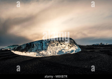 De la glace sur la plage volcanique noire près de glacier Jökulsárlón lagoon, hiver Islande. Détail d'un fragment de glace glaciaire à la magnifique plage de sable noir Banque D'Images