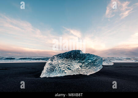 De la glace sur la plage volcanique noire près de glacier Jökulsárlón lagoon, hiver Islande. Détail d'un fragment de glace glaciaire à la magnifique plage de sable noir Banque D'Images