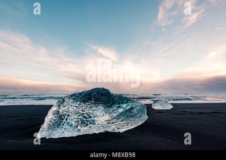 De la glace sur la plage volcanique noire près de glacier Jökulsárlón lagoon, hiver Islande. Détail d'un fragment de glace glaciaire à la magnifique plage de sable noir Banque D'Images