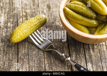 Cornichons dans la cuvette. Les concombres conservés savoureux sur la vieille table de cuisine. Banque D'Images