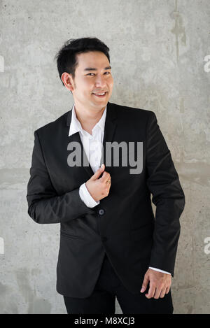Asian businessman avec fond de ciment gris. Banque D'Images