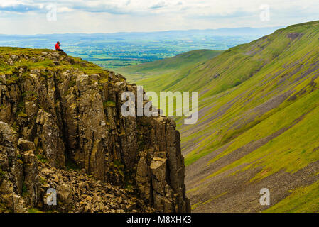 Walker prend une pause Coupe Haute surplombant un paysage spectaculaire de la North Pennines au-dessus de l'Eden Valley Cumbria Banque D'Images