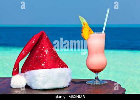 Bocal de verre est sur une table avec plage Santa hat (Maldives, l'Océan Indien) Banque D'Images