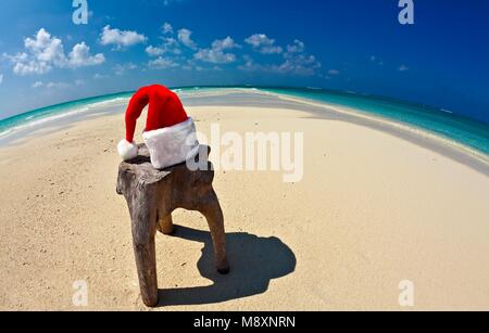 Santa hat est sur un tabouret original est fait de tronc d'arbre , Maldives beach Banque D'Images