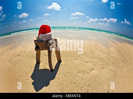 Santa hat est sur un tabouret original est fait de tronc d'arbre , Maldives beach Banque D'Images