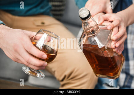 Garçon et père de boissons à la maison d'arrêt fils père de boire du whisky mains close-up Banque D'Images