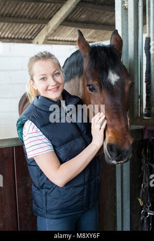 Portrait de femme propriétaire en Stable avec cheval Banque D'Images